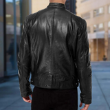 Giacca in pelle nera da uomo vista posteriore, stile motociclista, ambientata in un contesto urbano moderno. Moda maschile, abbigliamento casual.