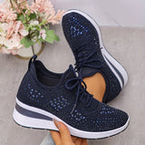 Scarpe da ginnastica nere con dettagli blu, suola bianca, su sfondo grigio. Design moderno e traspirante, perfette per sport e tempo libero.